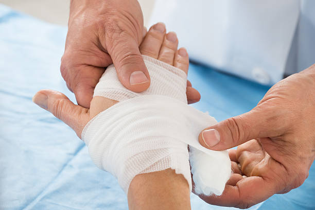 Close-up Of Person Hand Wrapping Bandage To Patient
