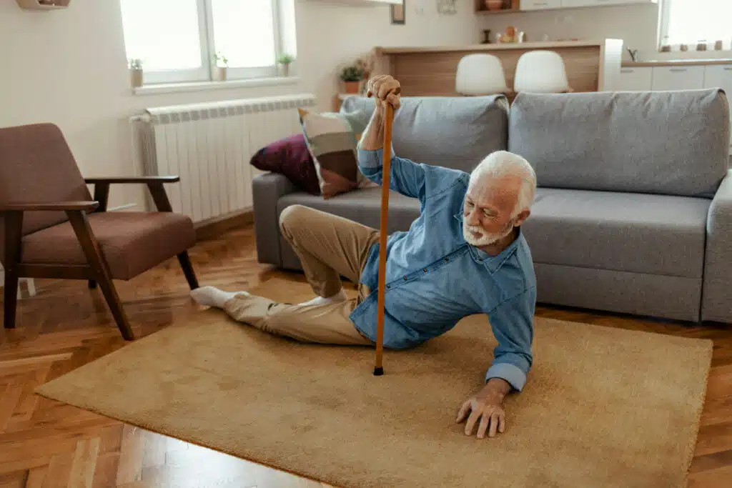 Elderly Senior Man with Osteoporosis slips and falls in the living room.